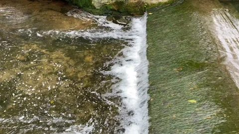 Stream of water rushing over stone surface creating bubbles Video stock 138155213