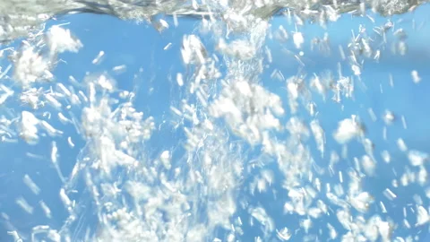 Stream of water in slow motion falls on  clean surface creating air bubbles Stock Footage 140246907