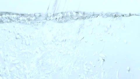 Stream of water in slow motion falls on  clean surface creating air bubbles Stock Footage 140247334