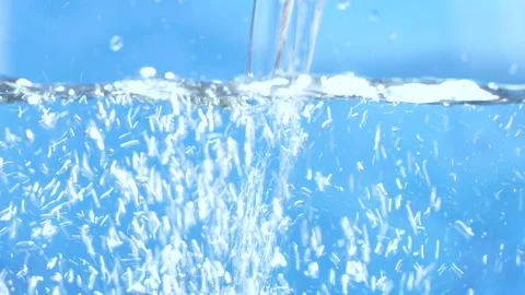 Stream of water in slow motion falls on  clean surface creating air bubbles Stock Footage 140247374
