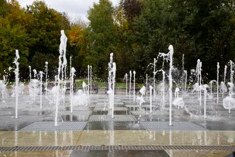 A stream of water splashes on the ground. A group of fountains Stock Photos