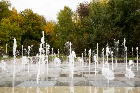 A stream of water splashes on the ground. A group of fountains Stock Photos