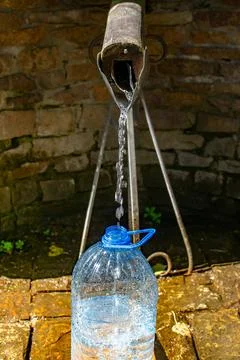 Stream of water from a spring with splashes pours into a bottle Stock Photos
