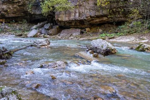 A stream of water in a stone riverbed, spewing noise and rumbling, making its Stock-Fotos