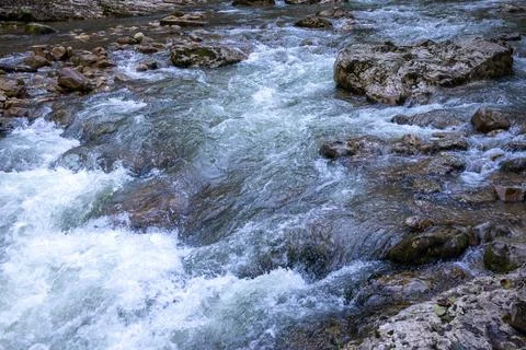 A stream of water in a stone riverbed, spewing noise and rumbling, making its Stock Photos
