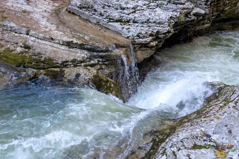 A stream of water in a stone riverbed, spewing noise and rumbling, making its Stock-Fotos