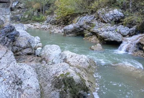 A stream of water in a stone riverbed, spewing noise and rumbling, making its Stock Photos