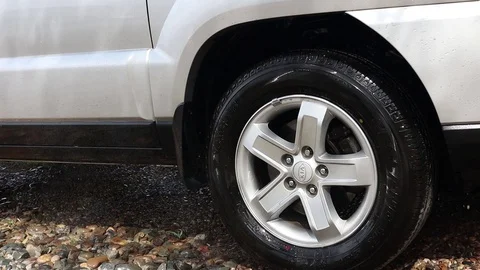 The stream of water washes the wheel of a car. Touchless car wash car at home. Stock Footage 128486168
