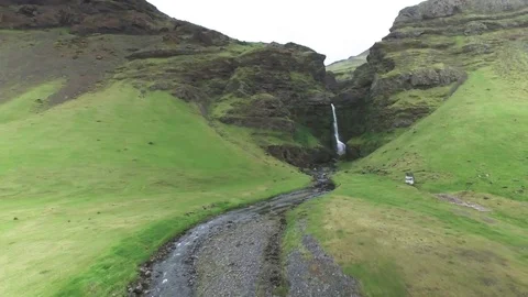 Stream of waterfall flowing through green mountainous region in Iceland Stock Footage 69741201
