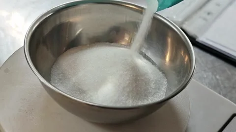 Stream of white sugar pouring into a stainless steel bowl. Stock Footage 342781566