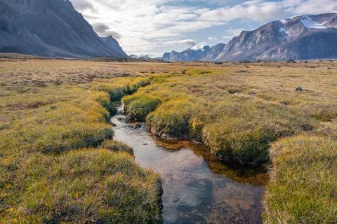 Stream winds through wild arctic landscape in Akshayuk Pass, Baffin Island Stock Photos