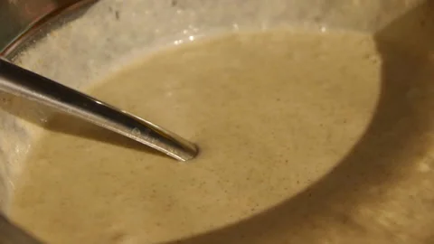 A stream of yellow pancake batter pouring from a ladle close-up Stock Footage 127060903