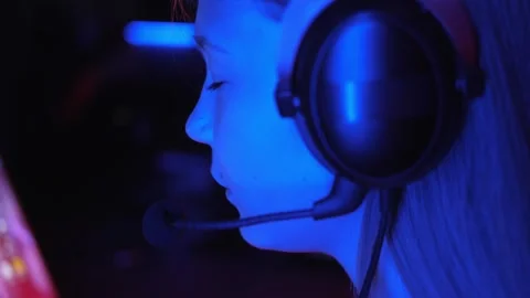 A streamer girl is playing an online computer game in a dark computer club. Stock Footage 330869479