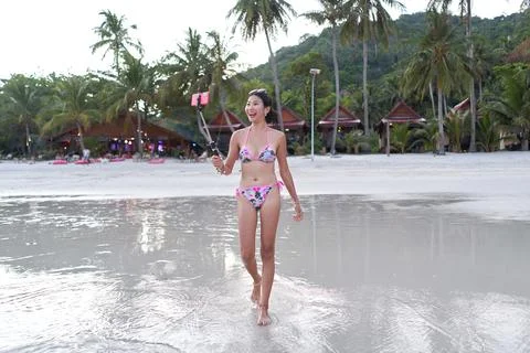 Streamer walking along the beach while performing live Stock Photos