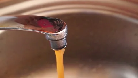 Streaming dirty rusty brown water in sink. Water stream going down the drain Stock Footage 157096983