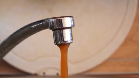 Streaming dirty rusty brown water in sink. Water stream going down the drain Stock Footage 157266144