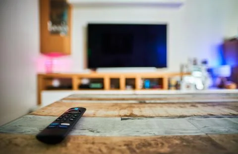 Streaming remote control on a table in a blurred living-room Stock Photos