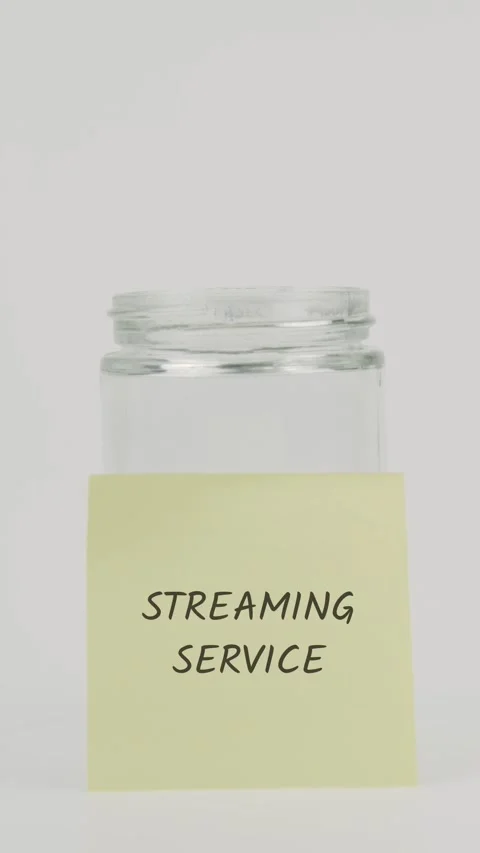 Streaming service text or word on yellow sticky note attached to glass jar Stock Footage 311791260
