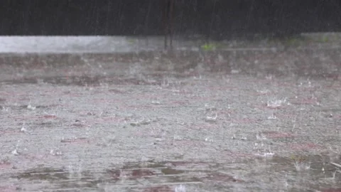 Streams and raindrops pour down an empty tiled pavement in 4K. Stock Footage 167499237