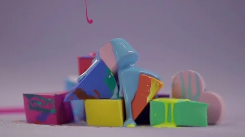The streams of pink varnish fall down on a pile of makeup sponges. Video stock 77512180