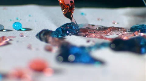 Streams of red, green and blue liquid splash onto white surface. Slow motion ECU Stock Footage 64886149
