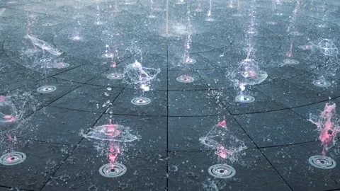 Streams spraying crystal water drops. Illuminated colorful droplets. Stock Footage 245741516