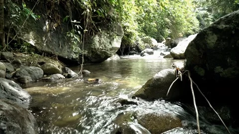 Streams of water flow between large rocks Video stock 279592488