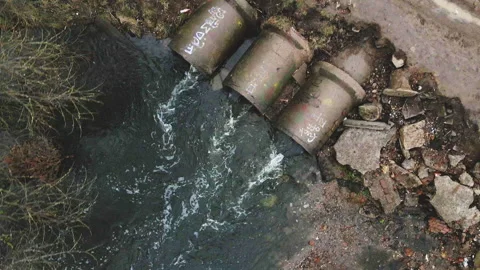 Streams of water flow through concrete sewers. Polluted body of water in the  Stock Footage 152479848