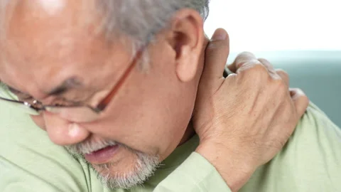 Streesed old male suffer while sit on sofa at home. Health care and insurance Video stock 219179353