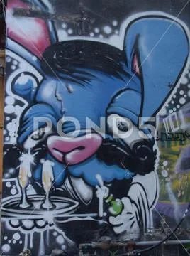 Street art at a wall building of a blue velvet and pink rabbit cute creature Stock Photos
