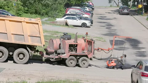 Street asphalt patch repairing procees at sunny summer day Stock Footage 198356002