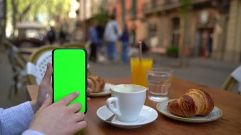 Street cafe breakfast using cellphone with green chromakey screen Vídeo Stock 237944152