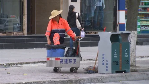 Street cleaner assembling her things in sidewalk Stock Footage 88687815