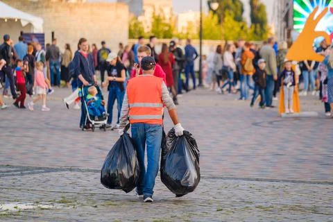 Street cleaner working on crowded square Stock Photos