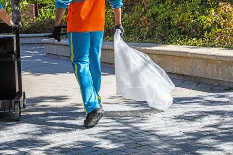 Street cleanliness workers walk with an empty trash bag. Environmental awar.. Stock Photos