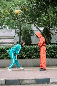 Street corner encounter featuring two people in distinctive tracksuits Stock-Fotos