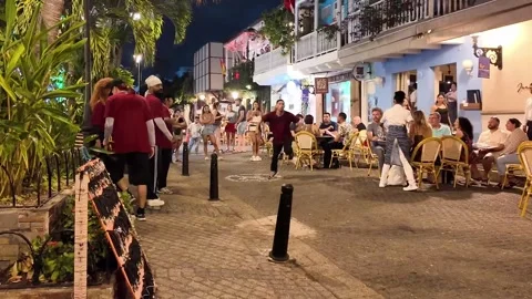 Street Dancer Performing Backflip in Front of Outdoor Restaurant Terrace at 스톡 동영상 340299846