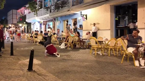 Street Dancer Performing Handstand Freeze Near Outdoor Restaurant Terrace at 스톡 동영상 340299660