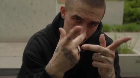 Street dancer performs a dance, making expressive movements with tattooed hands. Stock Footage 286877032