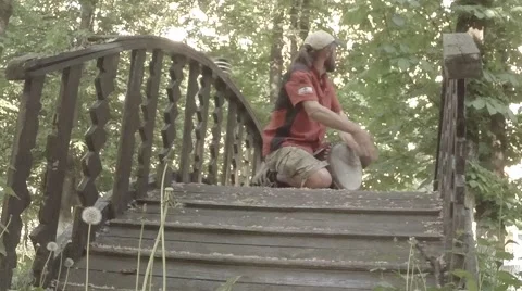 Street drummer plays hands on a makeshift drum on a wooden bridge in the park Stock Footage 50454930