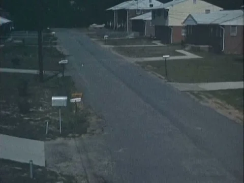 A street of evacuated houses is shown while the narrator explains the reasons Stock Footage 75299771