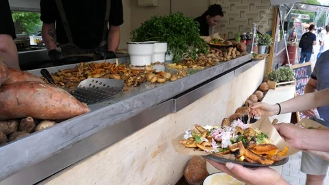 Street fast food truck point chef cook serves a dish of grilled vegetables  Stock Footage