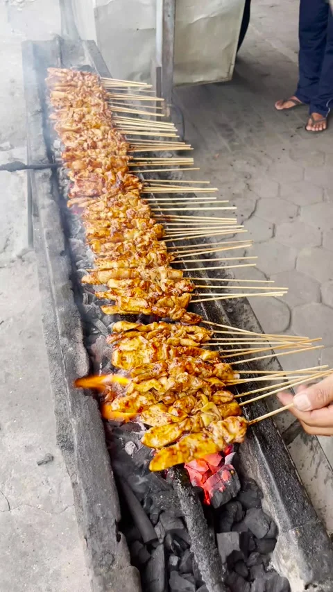Street Food a man is doing barbeque burning satay on charcoal grill Stock Footage 301741982