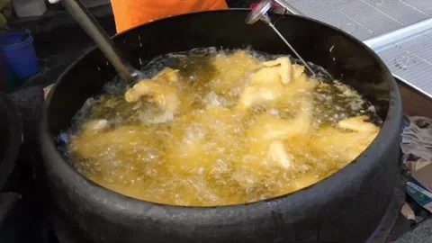 Street Food Vendor Deep Frying Chicken in a Large Cauldron Wok Stock Footage 343587853