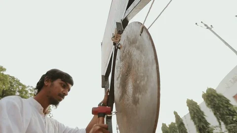 Street Holiday In India. Guy Knocks A Hammer In A Metal Disk. Stock-Footage 107269592