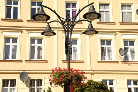 Street lamp with beautiful blooming flowers in front building outdoors Stock Photos