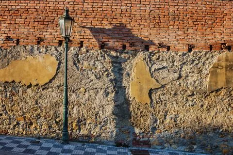 Street lamp with shadow on the background of broken brick wall Stock Photos