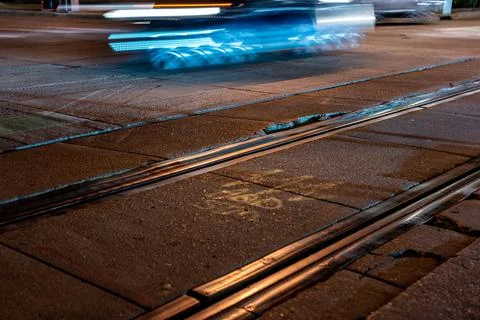 Street level selective focus on trolley rail lines at night in San Diego. Stock Photos