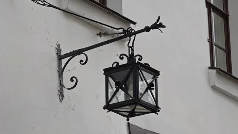 A street light hanging from the side of a building, great for urban or city.. Vídeos de archivo 345990038