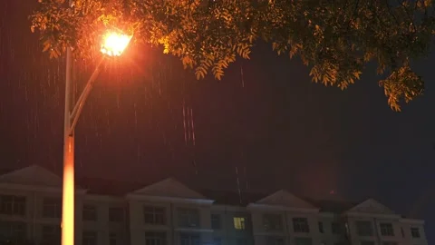 A street light outside a residential complex illuminating rain Stock Footage 153024895